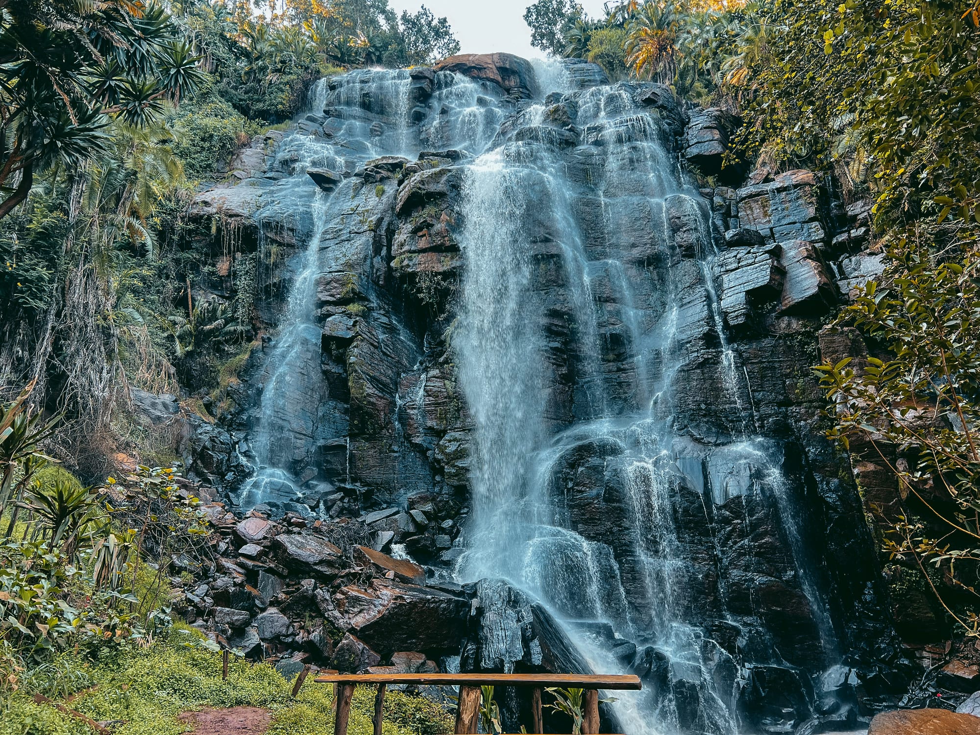 Guests hiking beside a waterfall in the Usambara Mountains